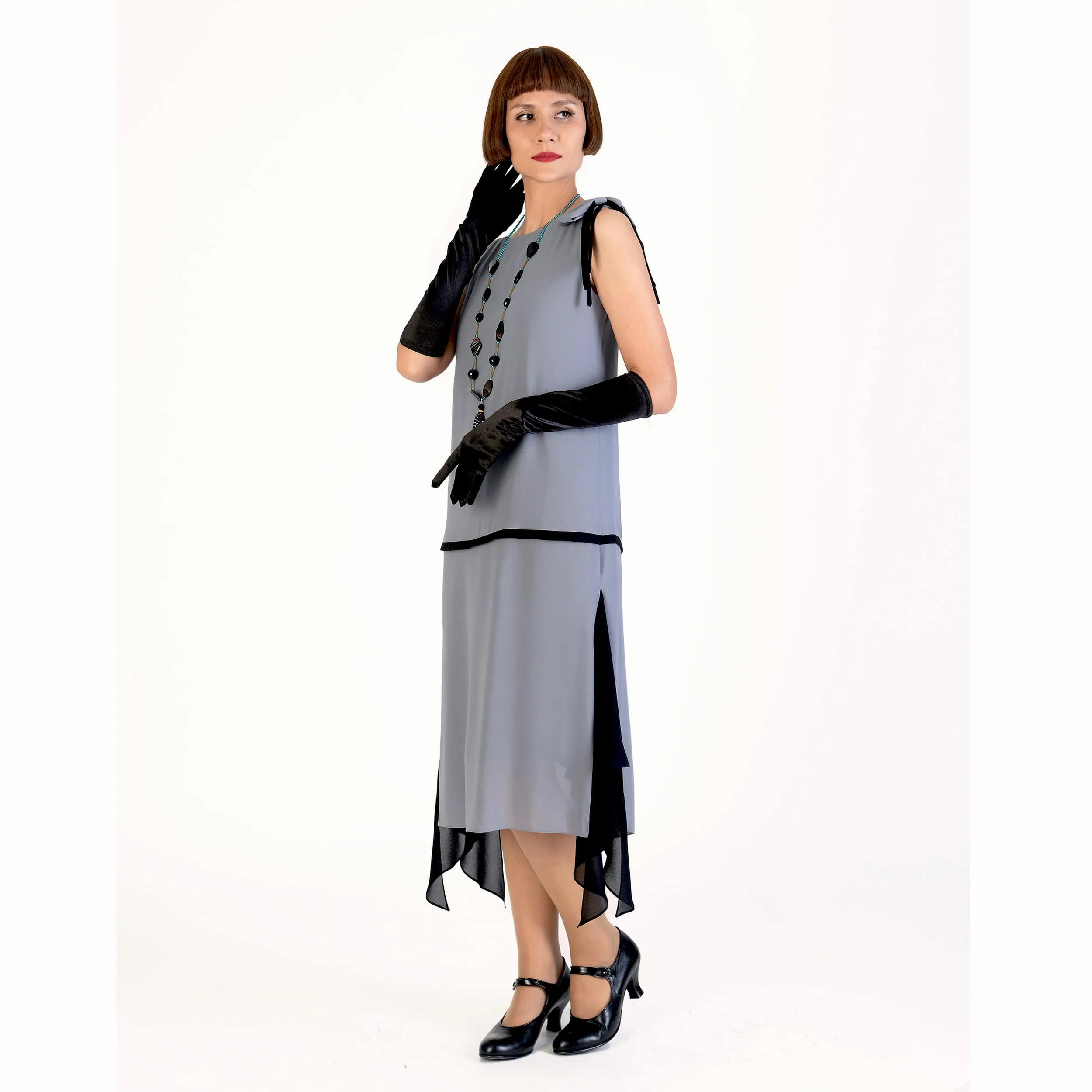 Grey party dress in 1920s style with black details and shoulder bow